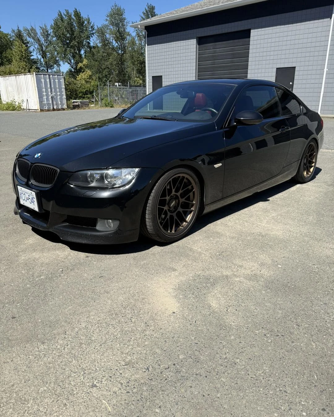Black BMW coupe outside a commercial building