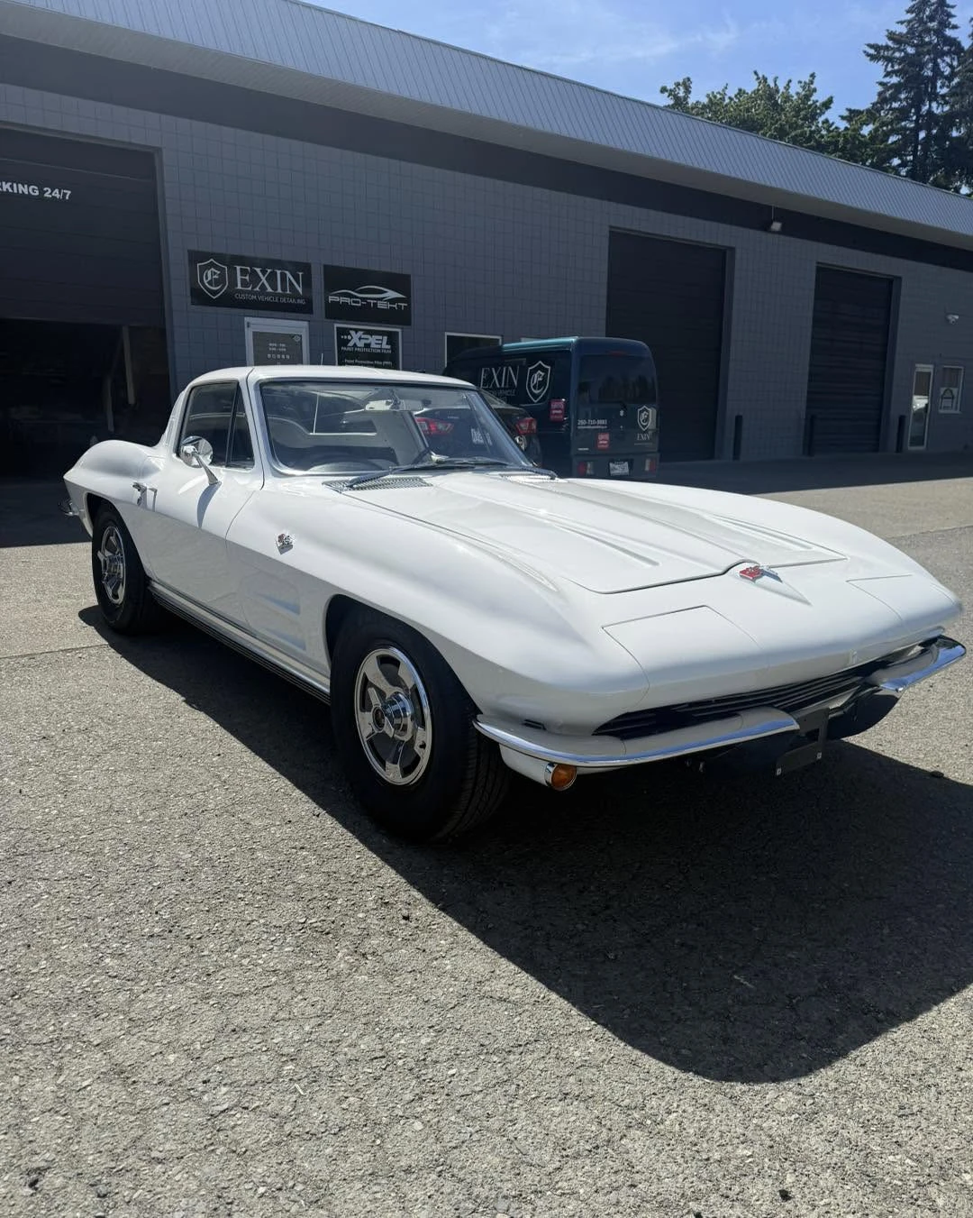 White classic Corvette outside the workshop