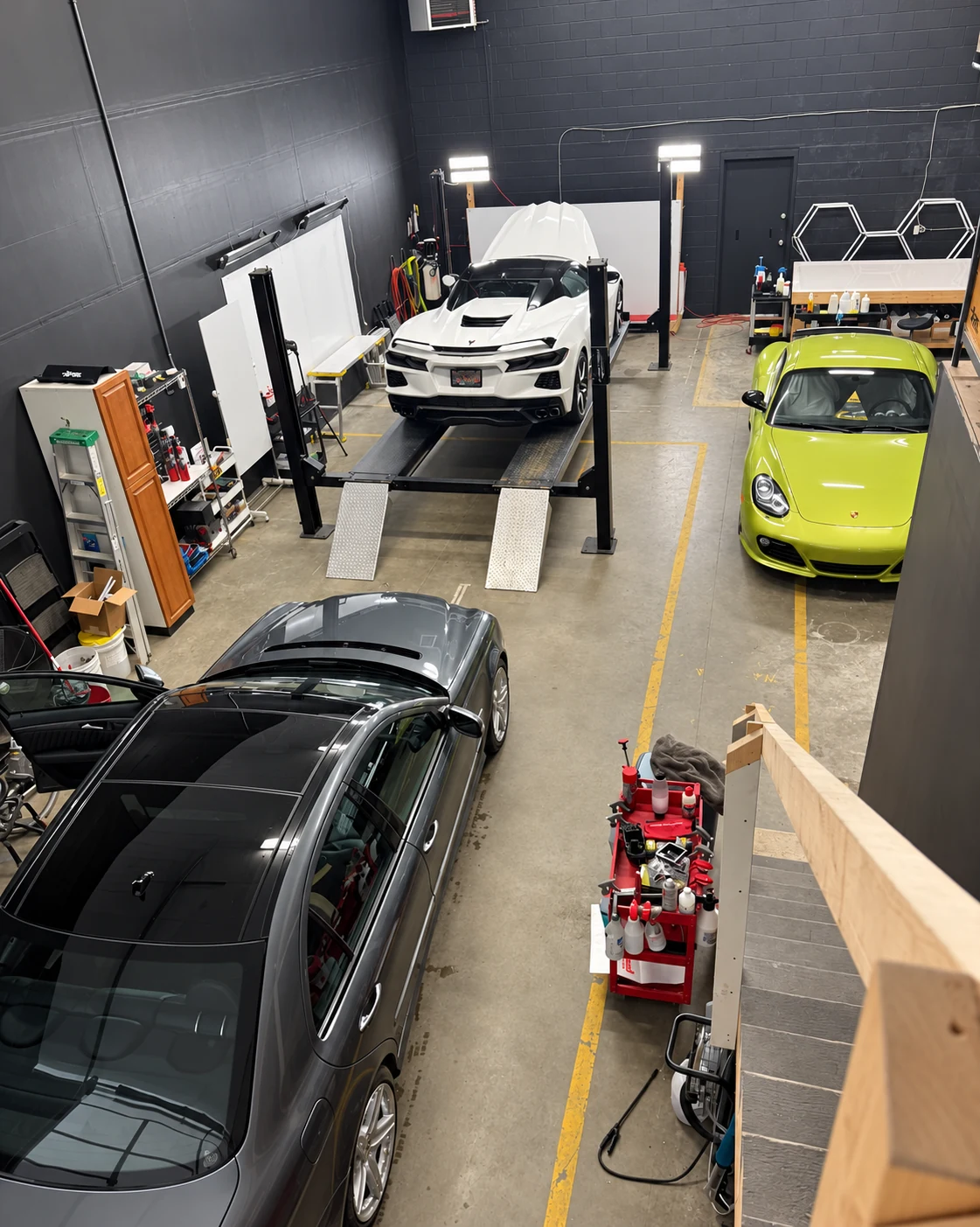 Vehicles, work lights and detailing equipment inside the Duncan shop