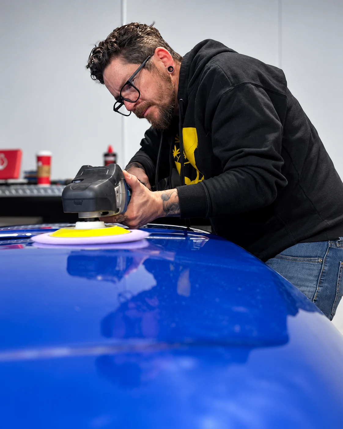 Jamie polishing the paintwork of a blue vehicle